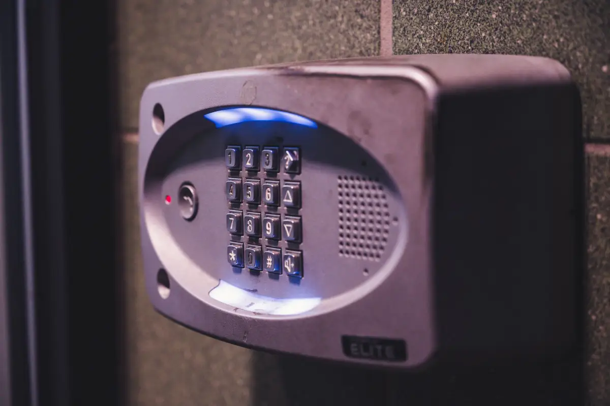 An illuminated gate entry keypad mounted at a driveway entrance