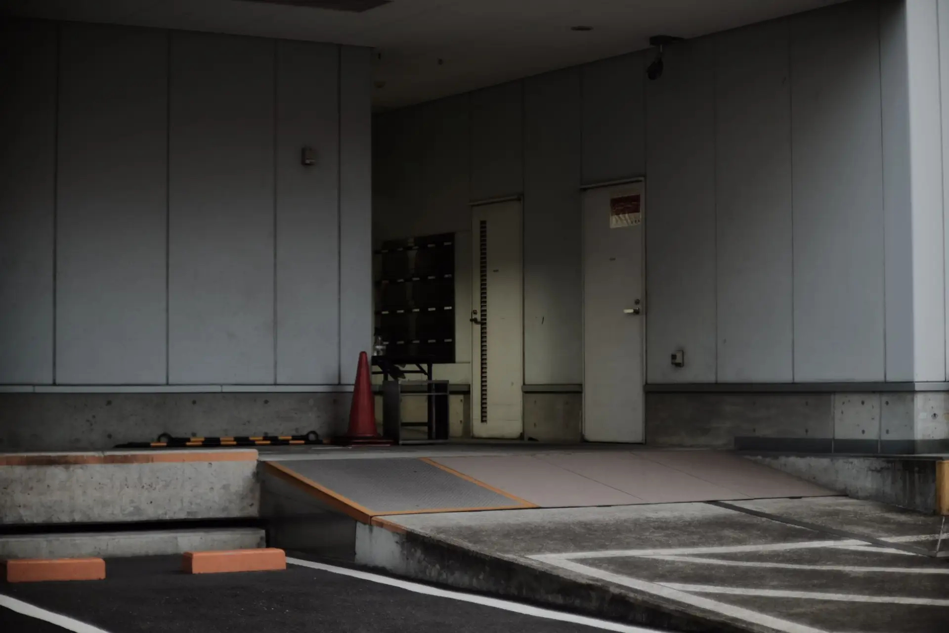 A commercial building entrance with a metal gate across the concrete driveway