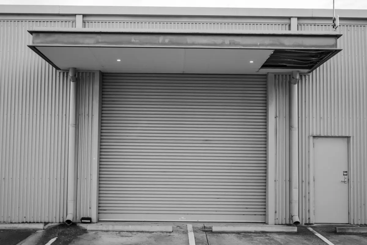 A heavy-duty steel gate closed across a commercial building entrance
