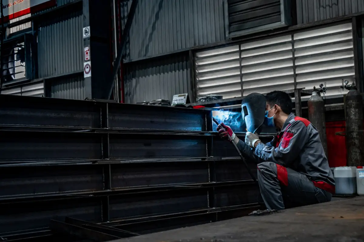 A welder fabricating a commercial gate frame in a workshop