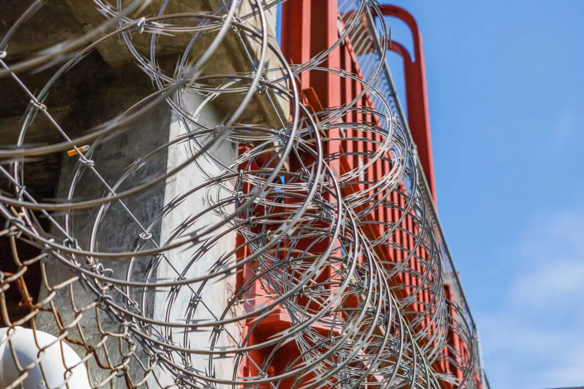Barbed wire topping an industrial perimeter security fence