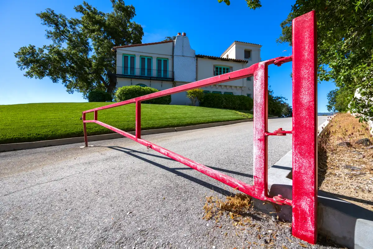 A metal driveway gate marking the entrance to a residential property