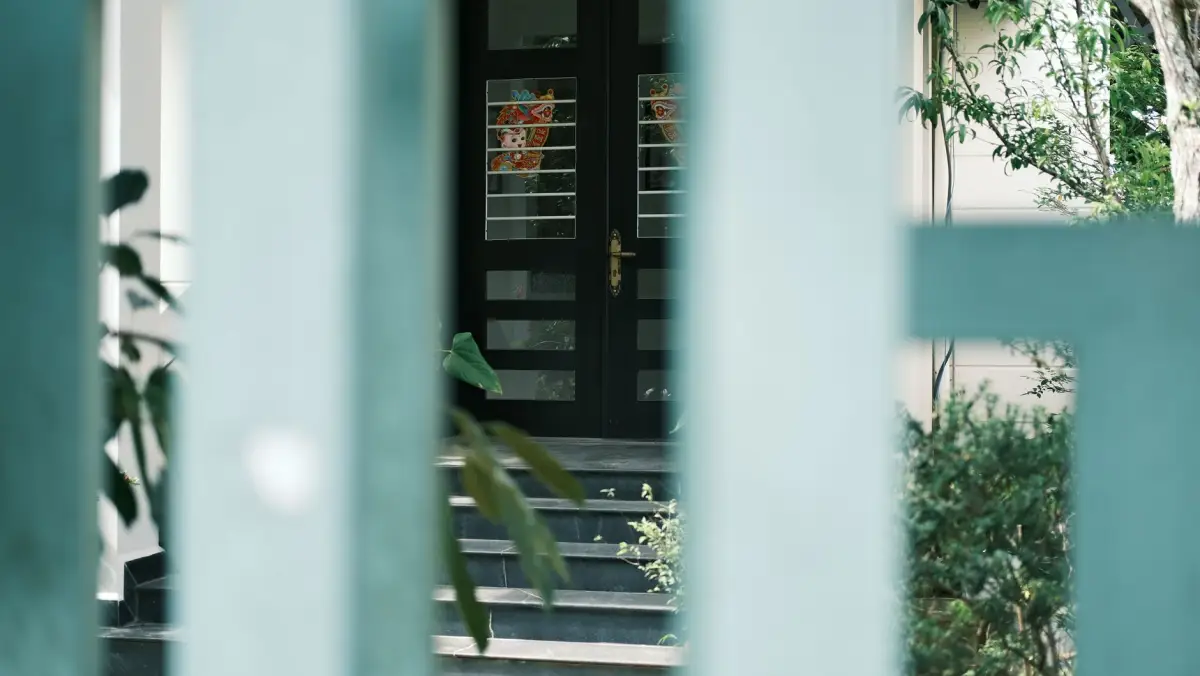 Driveway gates standing open onto a landscaped approach