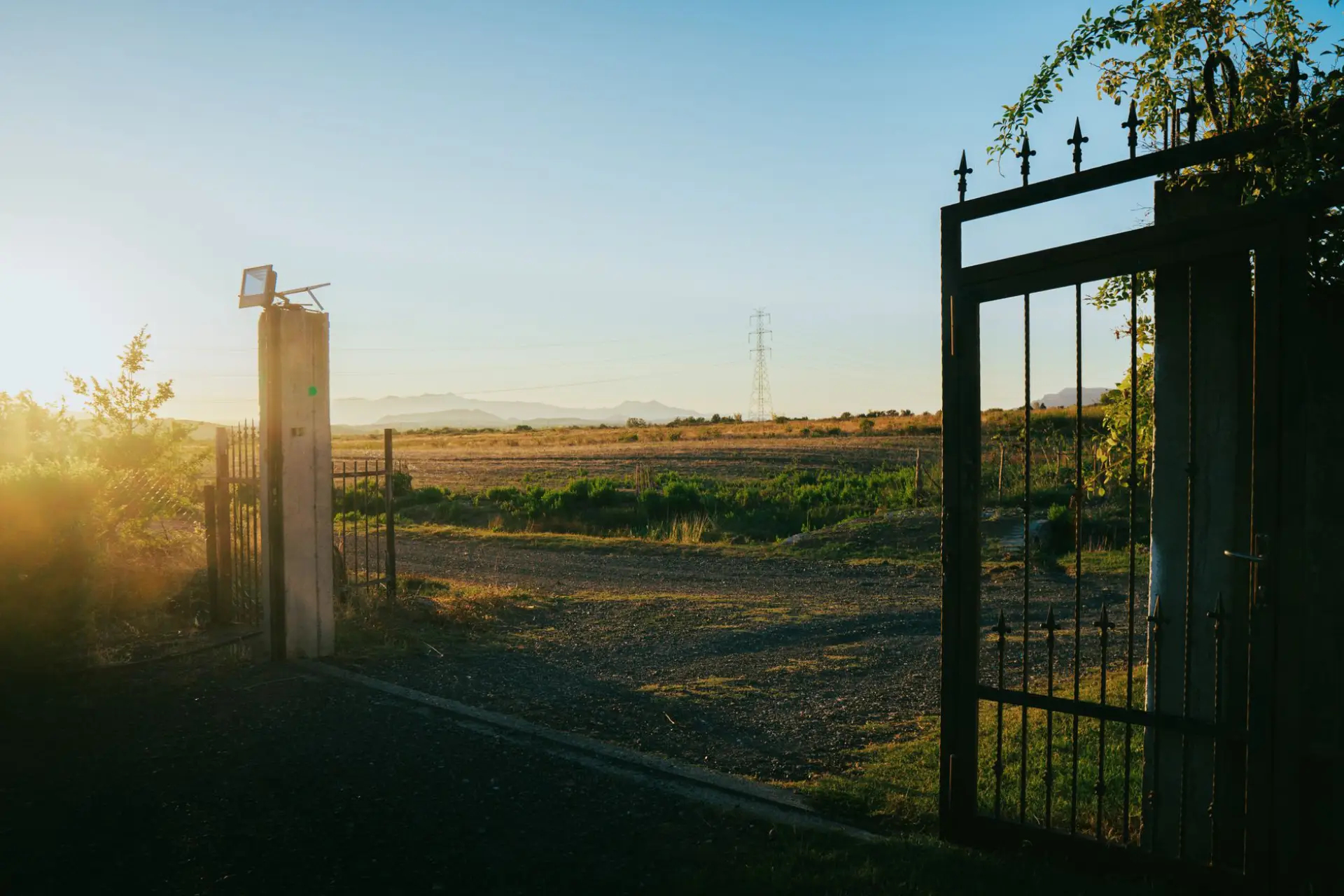 An automatic gate standing open at dusk