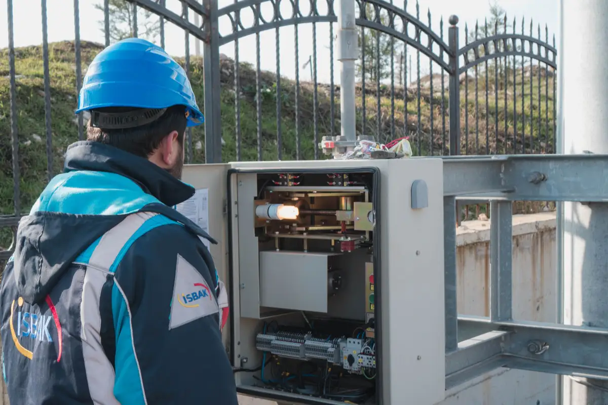 An electrician working on an outdoor power supply enclosure