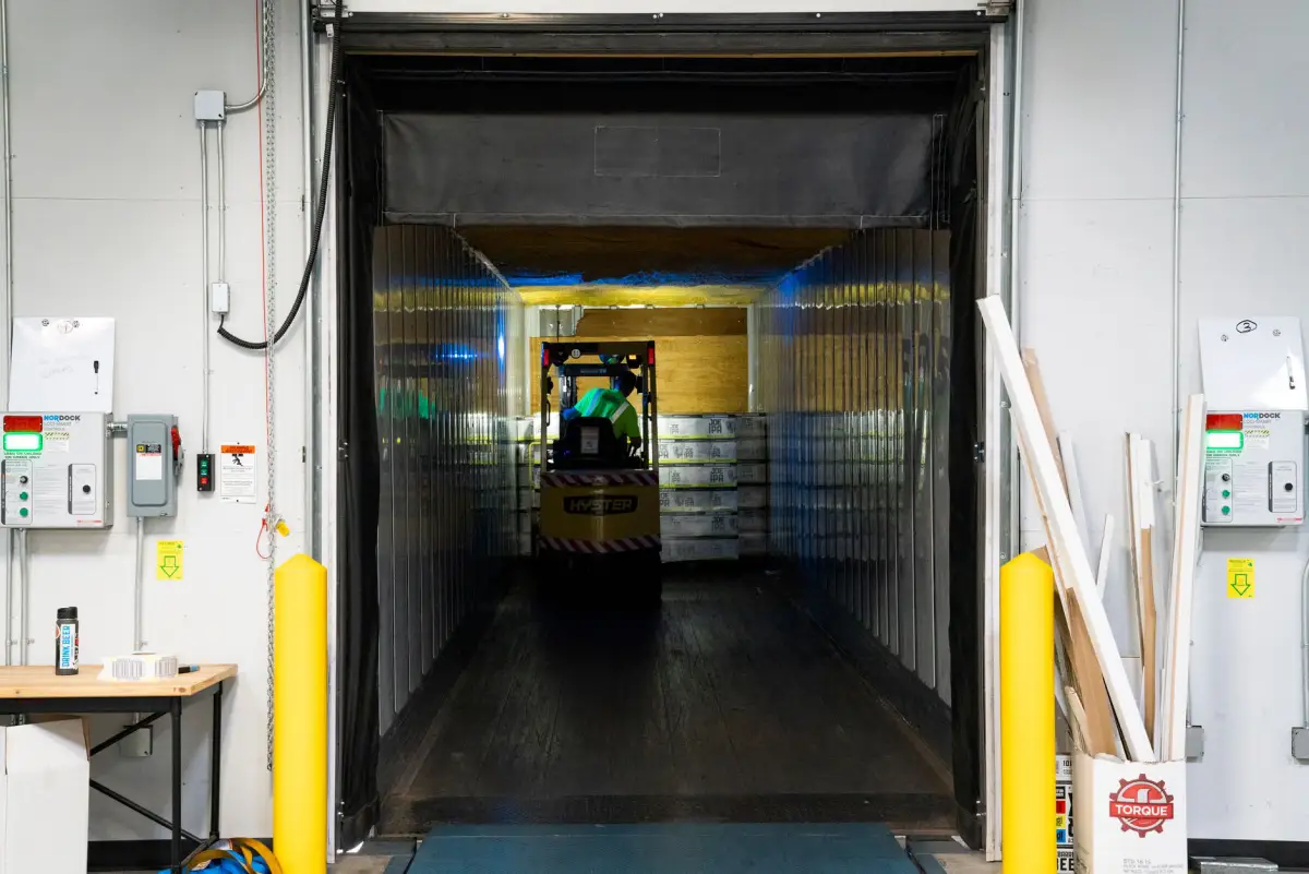 A forklift moving pallets inside a distribution warehouse