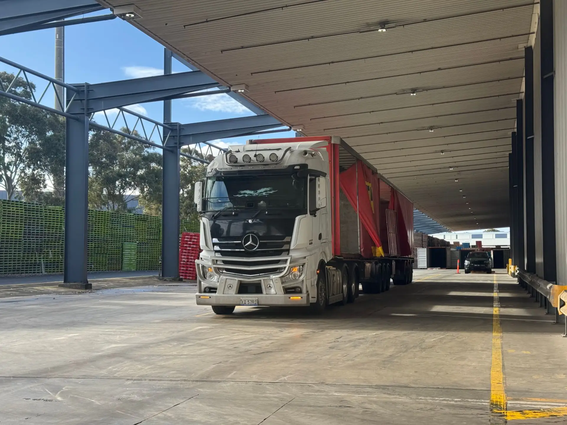 An industrial gate at a truck loading bay, trailer backed into the dock