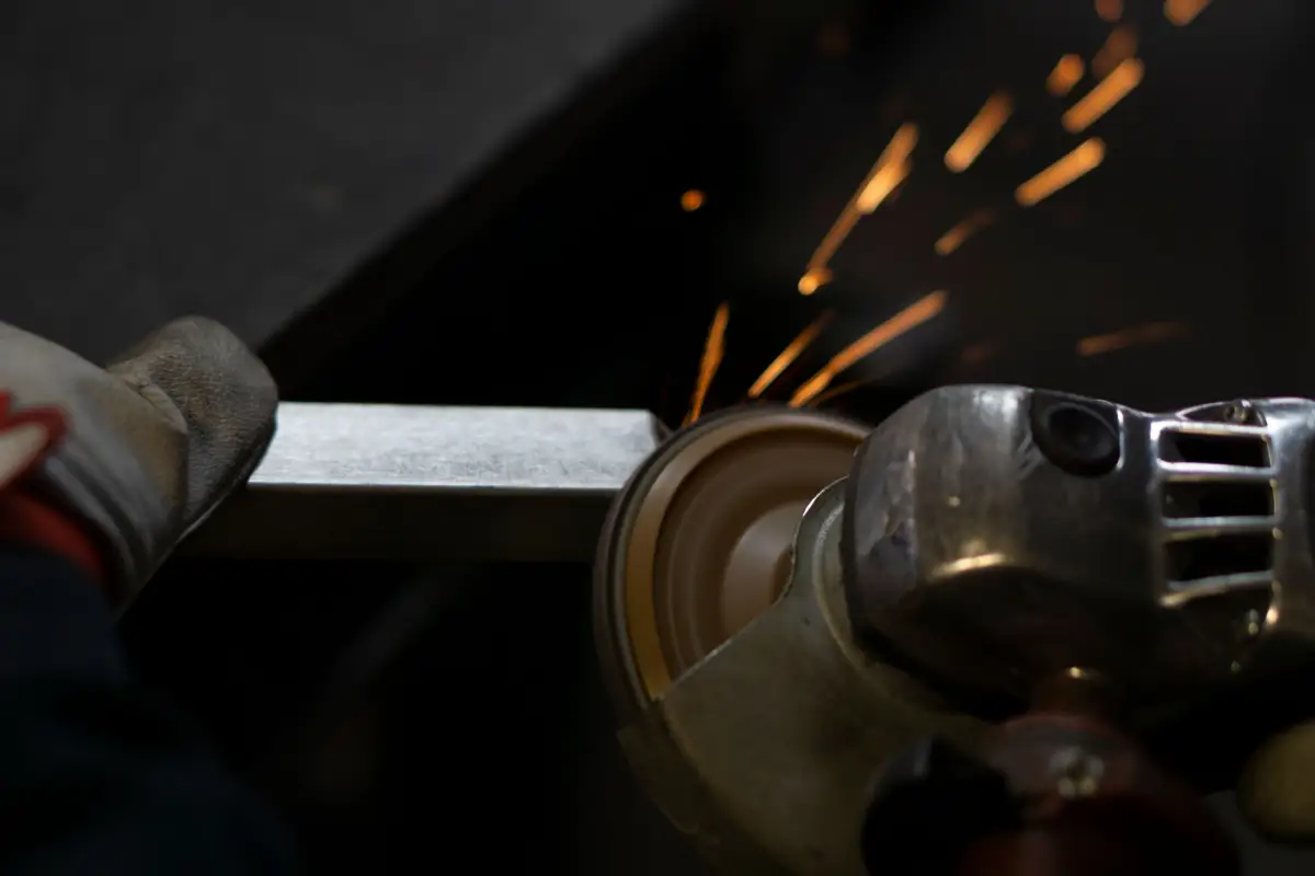 An angle grinder cutting steel during a gate repair, sparks flying