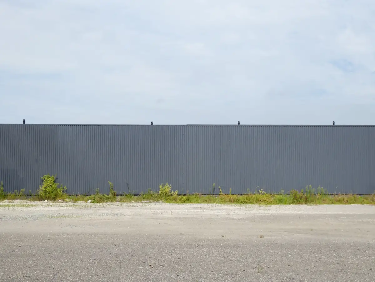 A secured metal perimeter fence running along a property boundary
